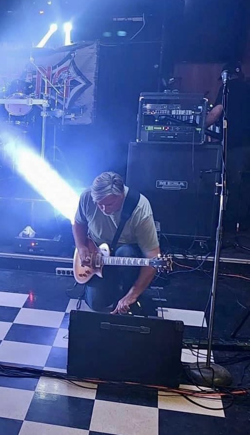 Guitarist on stage tuning his guitar