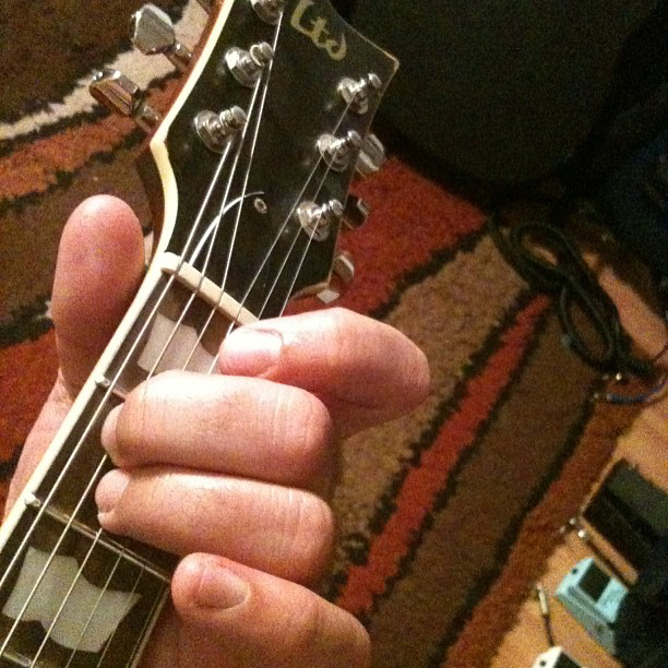 Photo of a E major chord demonstrated on the guitar