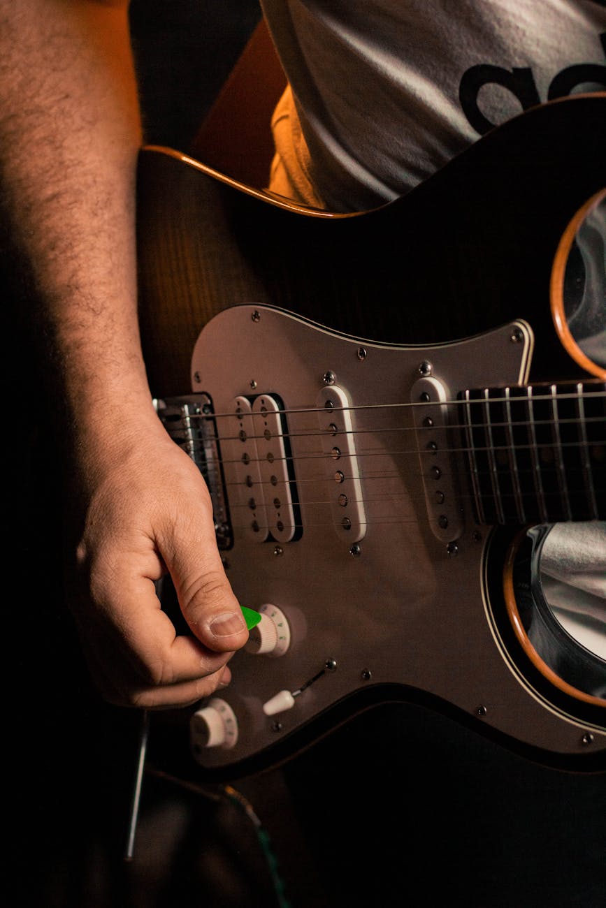 Intimate view of a guitarist's hand strumming an electric guitar, capturing the musical essence.