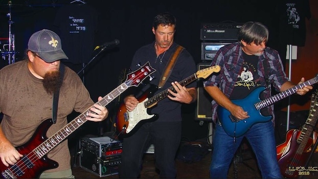 3 guitarists: Chuck, Joe, and Steve playing heavy metal on stage