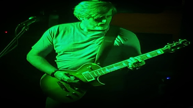 Steve Accardo playing the electric guitar in green light