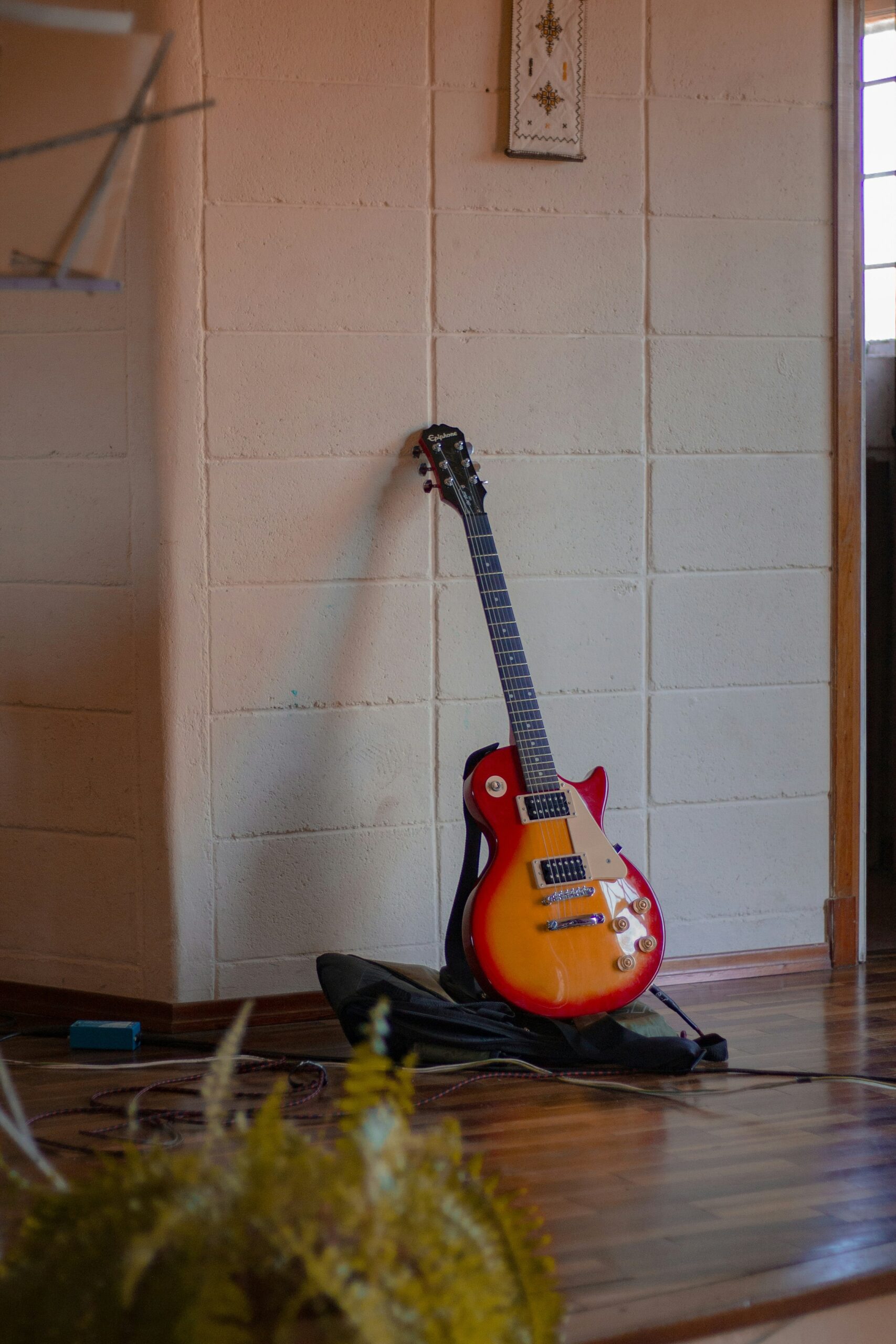 Epiphone les paul studio electric guitar leaning against a wall