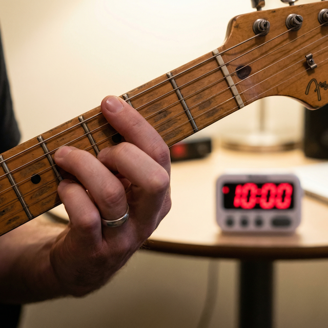 Close-up playing a chord with 10-minute timer.